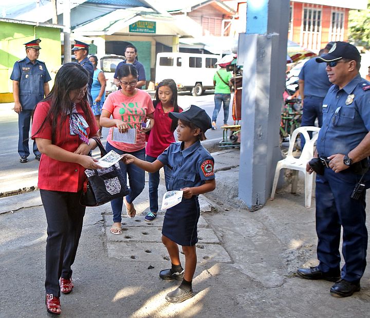 WELCOME BACK. Street children dressed in police uniform hand out fliers on safety tips to teachers and pupils attending the first day of class in Carlos Gothong Memorial High School.(CDN PHOTO/LITO TECSON)