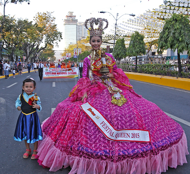 A girl carries her image of the Sto. Nino pose with Julienne Hazel Penserga, last year's Sinulog Festival Queen, during the opening Sinulog 2016 street parade along the Osmena Boulevard. (CDN PHOTO/JUNJIE MENDOZA)