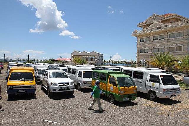 A City Hall employee (below) checks on some of the vehicles parked in front of the Sugbu building at the South Road Properties (SRP) after Acting Cebu City Mayor Margot Osmeña ordered the recall of all city-owned service vehicle for an inventory. (CDN PHOTO/JUNJIE MENDOZA)