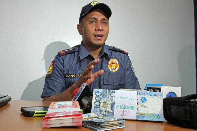 REWARD: Senior Insp. Henrix Bancoleta, chief of the Regional Anti-Illegal Drugs Special Operations Task Force (RDSOTF), shows the P155,000 they received from Mayor-elect Tomas Osmeña for their successful operation on Banacon Island, Getafe, Bohol where Rowen Secretaria, Central Visayas’ third most wanted drug personality,  and two others were killed. (CDN PHOTO/JUNJIE MENDOZA)