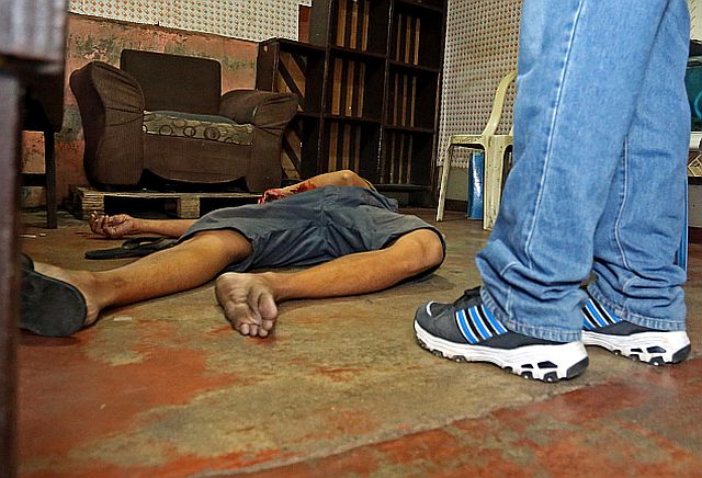 A homicide investigator of the Cebu City Police Office stands beside the lifeless body of Alfredo Domingo,  a suspected shabu user in Villagonzalo ll, Barangay Tejero, who was killed by an unknown assailant on June 9, 2016 (CDN PHOTO/LITO TECSON). 