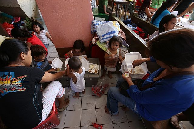 EATING TOGETHER. A family, who lost their house to Thursday’s fire, takes their breakfast at the chapel in Barangay Duljo Fatima. (CDN PHOTO/JUNJIE MENDOZA). 