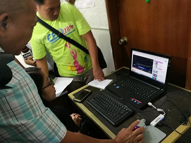 Woman wanted in Mindanao for human trafficking nabbed in Cebu NBI CEbu agents viewing the video of the molestation a baby girl, one of the evidences against a wanted human trafficker Liezyl Margallo, who was arrested in a resort on Malapascua Island on Wednesday. (CDN PHOTO/ CHRISTIAN MANINGO) 