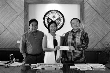 Naga City Mayor Kristine Vanessa Chiong receives the P1.3 million check from KSPC President Chang Yong Cho. contributed photo