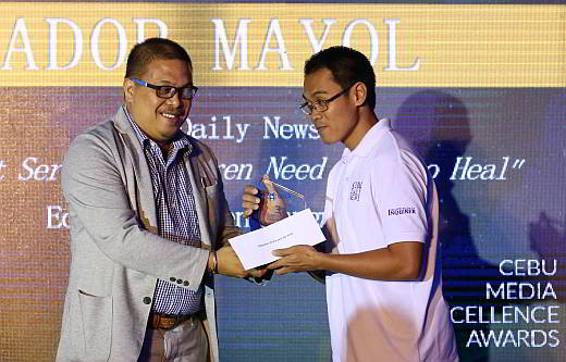  Cebu Daily News’ senior reporter Ador Vincent Mayol (right) receives a tropy from Globe Telecom legal counsel Mac Gordon during the 3rd Globe Cebu Media Exellence awards in the Marriott Hotel. (CDN PHOTO/JUNJIE MENDOZA)