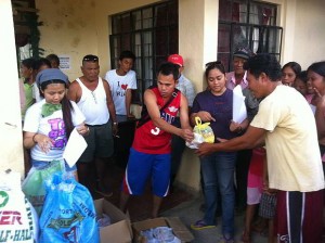 Junnette Pujida (left) and Jeff Garcia (in red shirt) help distribute relief goods to residents of barangay Langtad in Sagbayan, Bohol. (CONTRIBUTED PHOTO)