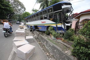 A Sunrays Bus driven by Ritchel Apondar rams into the fence of the house of Mary Ann Arnaiz in Perrelos, Carcar City. (CDN PHOTO/JUNJIE MENDOZA)