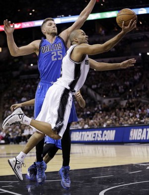 San Antonio’s Tony Parker shoots around Dallas’ Chandler Parsons in the second half of the Spurs’ thrilling 101-100 win over the Mavericks. (AP Photo)
