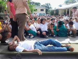 A pupil of the Mandaue City Central School acts as an injured victim during an earthquake drill yesterday, which is part of a simultaneous nationwide activity. (CDN PHOTO/ANIE PAUJANA)