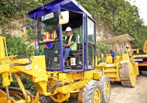 Gov. Hilario Davide III gets behind the wheel of a  grader to signal the start of the road repair project of   Sangi-Bugho road in San Fernando town during the inauguration ceremony yesterday.  At the back is Vice Governor Agnes Magpale (in white hard hat)  who was on a steam roller. (CDN PHOTO/LITO TECSON)