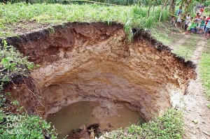 A HOLE NEW WORLD. A sinkhole appears in barangay Banhigan,  Badian town after the storm. (CDN PHOTO/ TONEE DESPOJO)