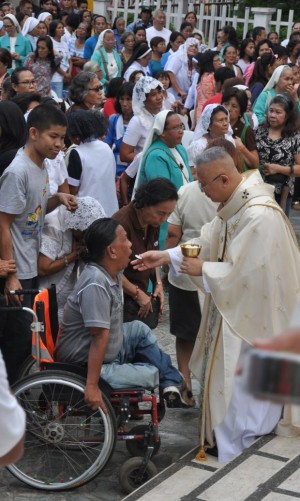 communion. Cebu Archbishop Jose Palma administers the holy communion to a person with disability. (CDN PHOTO/ CHRISTIAN MANINGO)