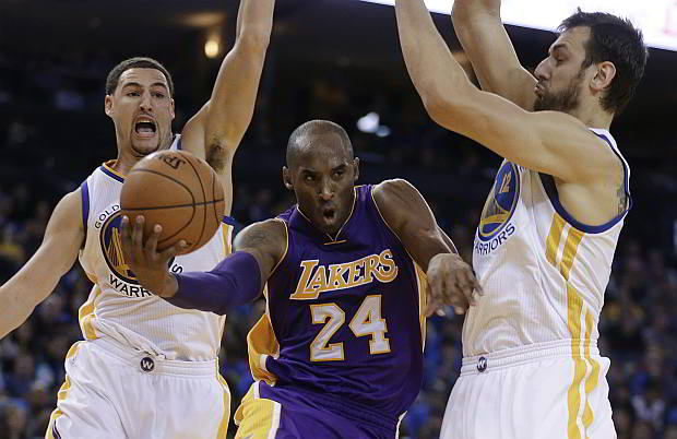 Los Angeles Lakers' Kobe Bryant drives between Golden State Warriors' Klay Thompson (left) and Andrew Bogut. (AP)