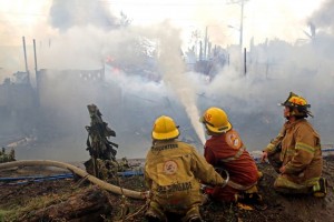 Fire fighters try to contain the fire that hit informal settlers in sitio Mahusay, barangay Subangdaku, Mandaue City last Dec. 4, 2014.