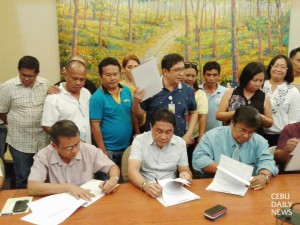 Reconciliation. Argao Mayor Edsel Galeos and DENR-7 Regional Director Isabelo Montejo sign the MOA to jointly implement the town’s FLUP, with Cordova Mayor and LMP Cebu Chapter Vice Pres. Adelino Sitoy witnessing. (CDN PHOTO/PETER  L. ROMANILLOS)