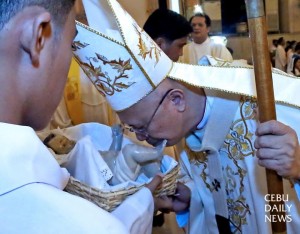 Archbishop Jose Palma (right) kisses the image of the baby Jesus Christ after celebrating the Christmas eve mass at the Cebu Metropolitan Cathedral. (CDN PHOTO/JUNJIE MENDOZA)