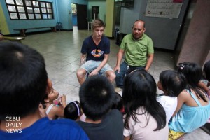 Danish intern Mathias Lykke Rasmussen (left) who is studying  social education, and Redentor Betito, program director of the Children of Cebu Foundation, meet with street children at the Pari-an Drop-in Center in Cebu City. (CDN PHOTO/JUNJIE MENDOZA)