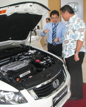 SOCIAL RESPONSIBILITY. File picture shows Honda Cars Cebu Inc. general manager Tito Solomon (left) attending to a customer in their showroom in Nivel Hills, Lahug. The Cebu Automotive Dealers Association has agreed to help City Hall promote road courtesy.  (CDN FILE PHOTO)