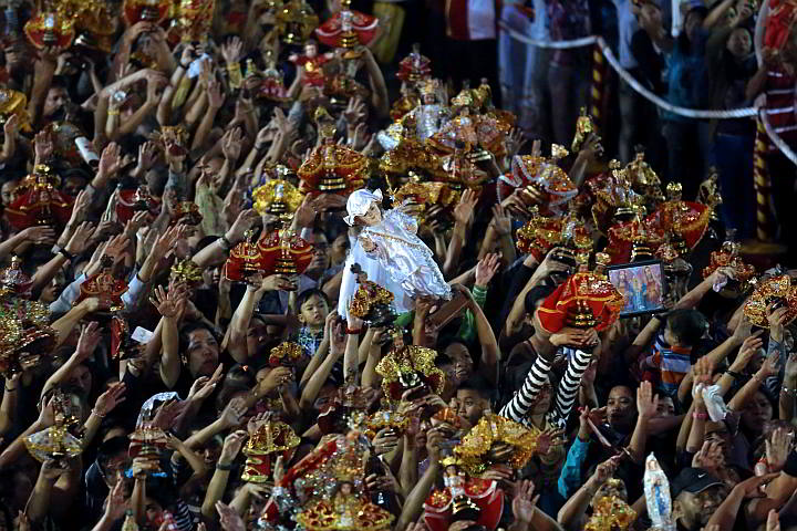 Sto. Nino devotees wave their icons of Sto. Nino as the gozos 'Bato Balani sa Gugma' is played. (CDN PHOTO/ JUNJIE MENDOZA)