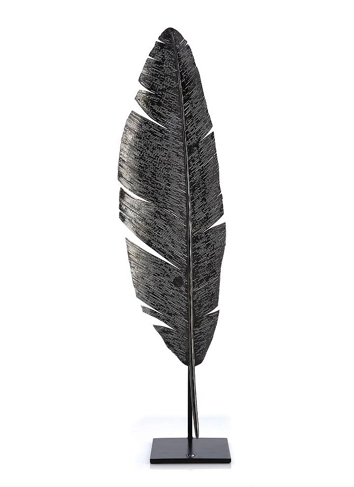  Michael Aram’s nickel  plated feather sculpture is an arresting example of the feather motif.  Designer Christina McCombs  says it’s one of her favorites:  “I can see this placed on  a great console in an entryway  or placed on a stack of coffee table books on a low bookcase.”