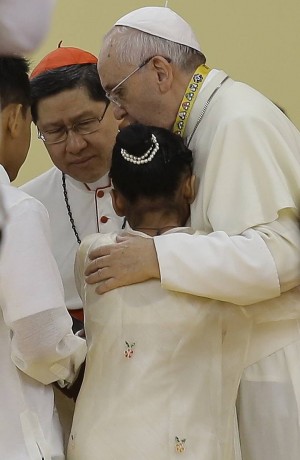 Pope Francis hugs two former street children during his meeting with youths in University of Santo Tomas. (AP Photo)