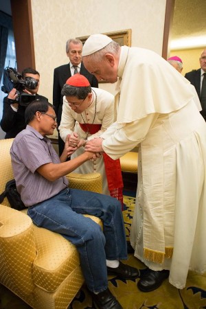 Pope Francis and Cardinal Luis Antonio Tagle meet the father of Kristel Padasas, a young Catholic volunteer who was killed in an accident at the site of the Tacloban Mass. The meeting took place in the Vatican Embassy to the Philippines. (AP Photo)