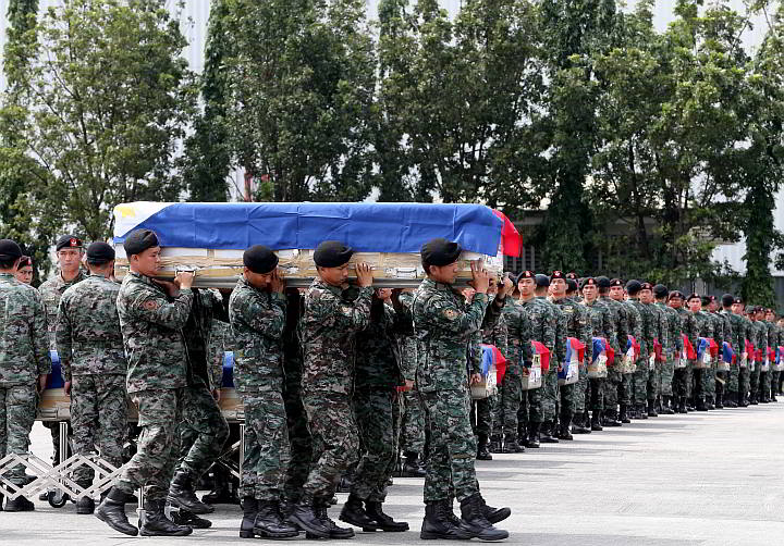 Black berets identify   members of the Philippine National Police Special Action Forces who  carry the coffins of their comrades upon arrival at Villamor Air Base in Pasay City.  The flag-draped coffins bear  the bodies of 42 of the 44 policemen killed last Sunday in Maguindanao. (AP Photo)