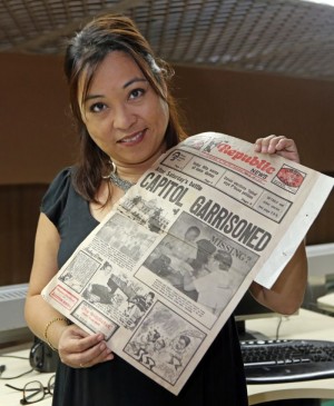 Media executive Rosemarie Holganza-Borromeo (above) shows one of the old newspapers that her late father, Dodong, kept. (CDN Photo/Lito Tecson