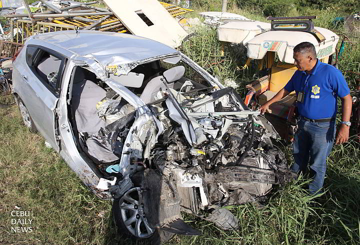 A Citom traffic enforcer inspects the wrecked Hyundai sedan that collided with a trailer truck and killed all five people on board at the South Coastal Road (SCR) last Sunday dawn.  (CDN Photo/Junjie Mendoza)