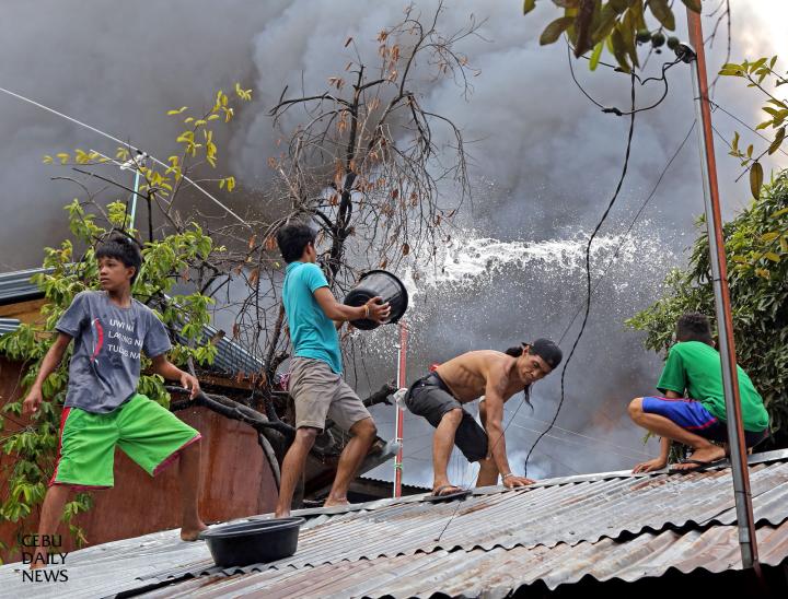 Residents of sitio Ulap and Laguna in barangay Basak Pardo fight through the haze of smoke swept through their area. (CDN PHOTO/ LITO TECSON)