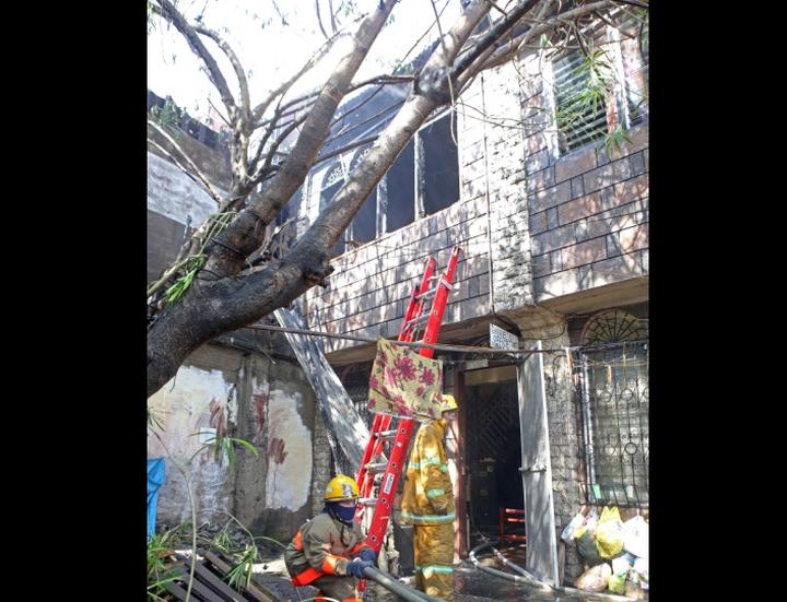 A fireman drags a fire hose as he tries to put out a fire that struck an apartment in barangay Sambag Uno, Cebu City yesterday. (CDN PHOTO/ LITO TECSON) 
