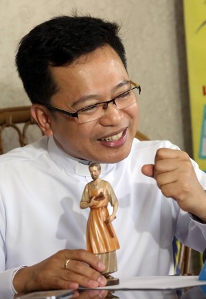 Fr. Dan Delos Angeles with an image of  St. Joseph, said he got help in passing the Bar by assigning saints for each subject. (CDN FILE PHOTO)