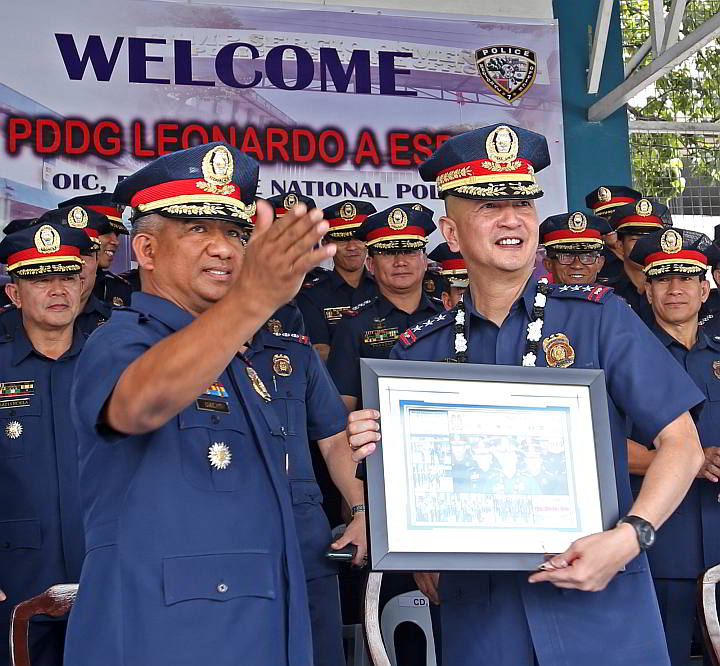 PNP Deputy Director General Leonardo Espina (right) recieves a token framed photo montage from Chief Supt. Orlando Ualat, OIC of the Police Regional Office (PRO7) upon his arrival at Camp Sergio Osmeña Sr. in Cebu City. (CDN PHOTO/JUNJIE MENDOZA)