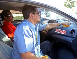 LTFRB 7 head Reynaldo Elnar Chief places a  sticker notice on the P10 flag down rollback on the dashboard of a taxi at SM City‘s parking lot. Will passengers assert their right now? (CDN PHOTO/LITO TECSON)