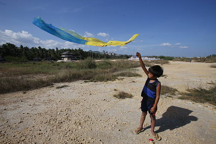 Nine-year-old Junel Margallo plays with his kite at one of the submerged portions of the Balili property in the City of Naga, south Cebu.  (CDN Photo/Junjie Mendoza)