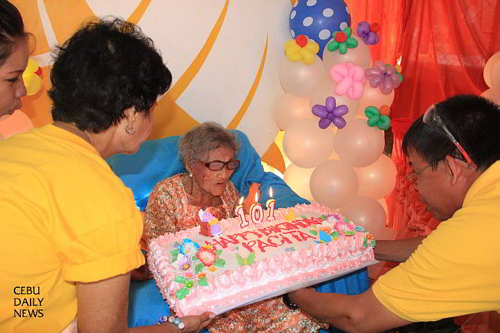 Pacita Aubejero, 101, makes a wish and blows the candles of her birthday cake at her home in the Mactan Air Base (CDN PHOTO/ NORMAN MENDOZA)