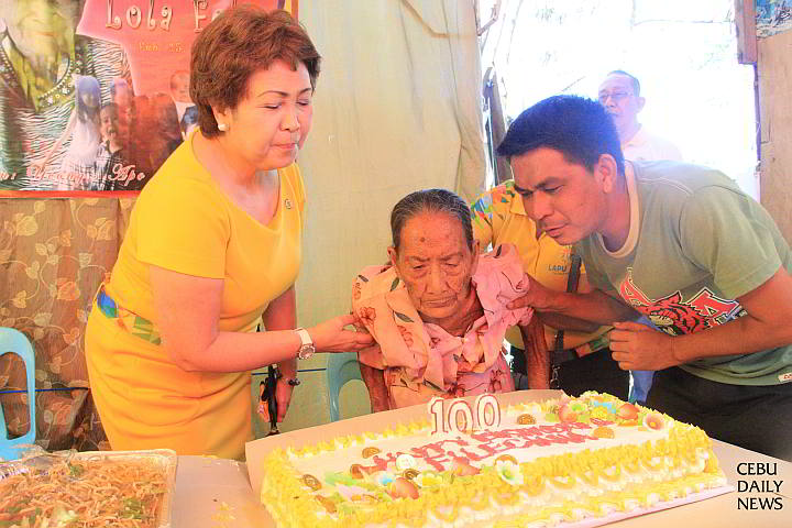 Mayor Paz Radaza assists Feliciana Pagobo, 100, at the latter’s home in Sitio Malingin barangay Punta Engaño (CDN PHOTO/ NORMAN MENDOZA)