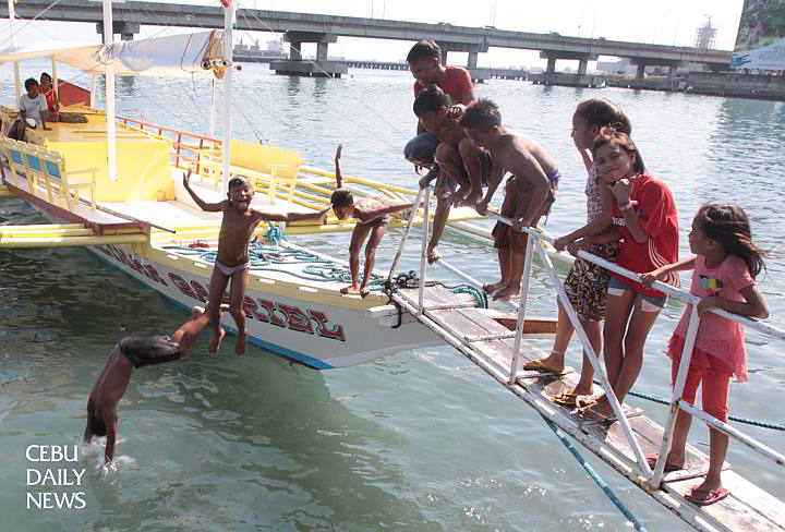 Children from barangay Pasil and Suba, Cebu City cool off with a dip in the waters off  the Pasil fish port. (CDN PHOTO/JUNJIE MENDOZA)