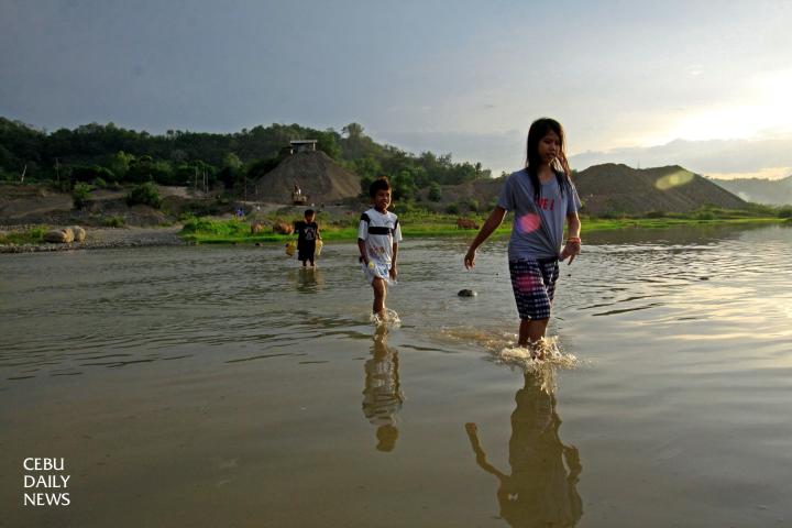 TROUBLED WATERS. Children cross the calm Sapangdaku river near barangay Cambang-ug, Toledo City. Sand and gravel quarrying has resulted in increased landslide and flood hazards in communities near the river. (CDN PHOTO/ LITO TECSON)