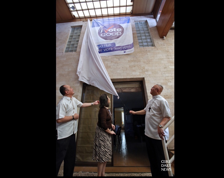 Cebu Archbishop Jose Palma (right) assisted by Fr. Carmelo Diola (left) of Dilaab Foundation and Marilou Chiongbian, C-CIMPEL executive director unveil the “I Vote Good” tarpaulin in their new office at Espina Village. (CDN PHOTO/JUNJIE MENDOZA)