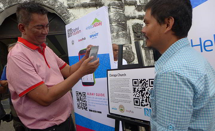 Albay Governor Joey Salceda demonstrates the downloading of information via phone scanning through the interactive Digital Tourism marker deployed by InnoPub Media in collaboration with Smart Communications, Inc. and the Albay Provincial Government.