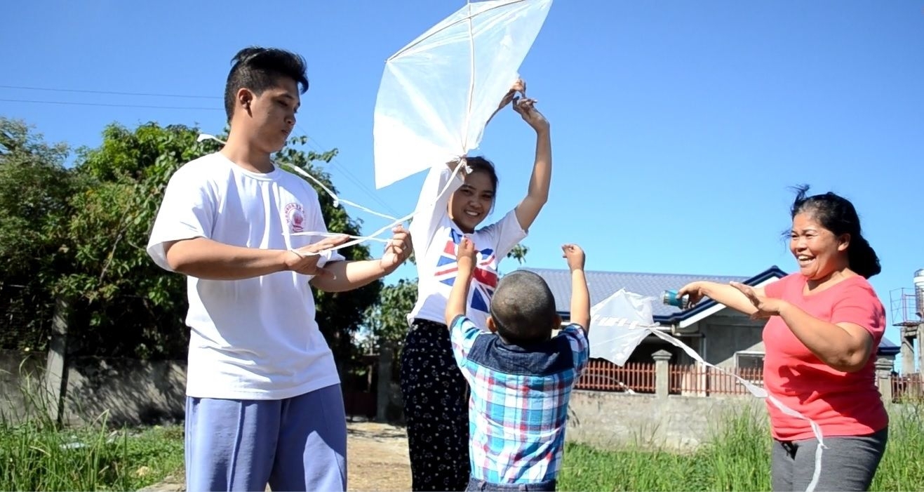 David (back to camera) plays kites with his foster family. (Contributed Photo)