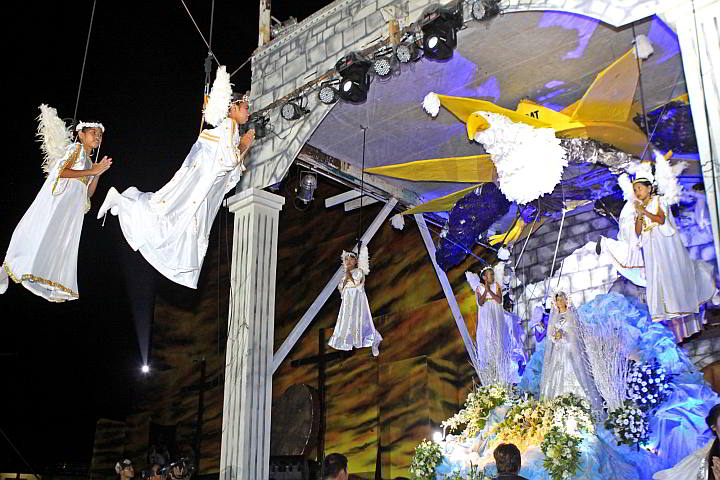 The Catholic faithful in Minglanilla town watch  children dressed as angels and suspended from wires  in a reenactment of the Resurrection of Jesus Christ. (CDN PHOTO/ LITO TECSON)