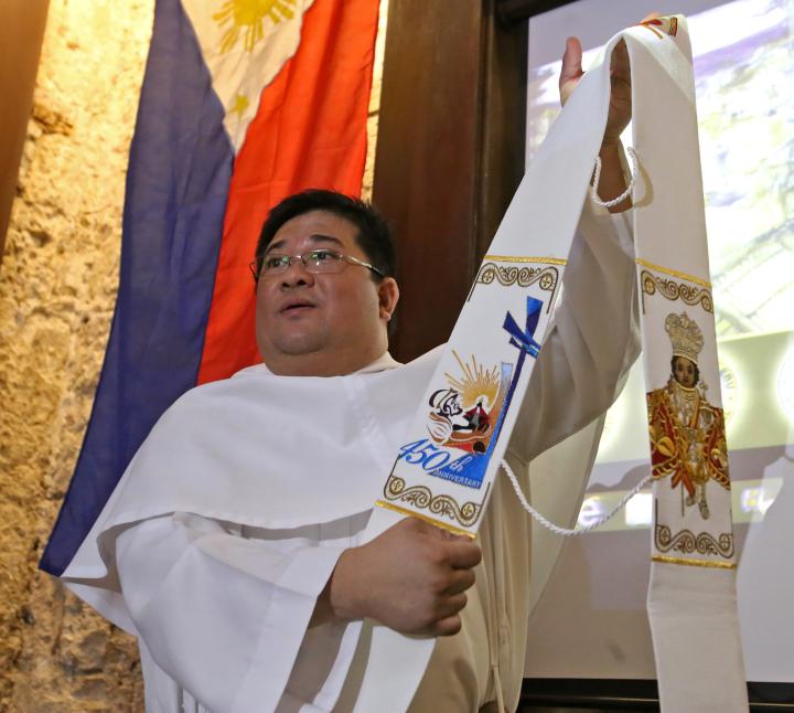 Fr. Harold Rentosa, Kaplag executive director, shows the new stoles which priests will wear over their robes. Worn over the shoulders, the scarf-like garment will have the logo of the 450th Kaplag and image of the Sto. Nino. (CDN PHOTO/ JUNJIE MENDOZA)