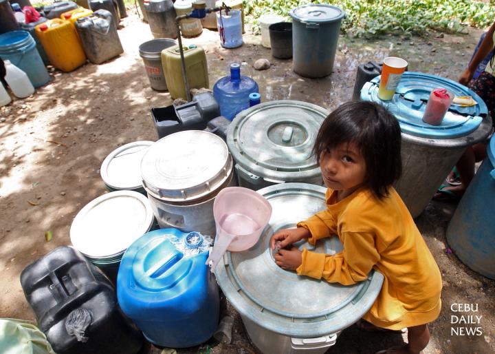 In the upland barangay of Maghaway, Talisay, a child watches over her family's water rations. (CDN PHOTO/ TONEE DESPOJO)