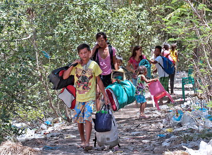 Settlers in the Inayawan landfill, along with their children, carry their belongings after being told to move out of the “danger zone” posed by heaps of garbage that could collapse.   (CDN PHOTO/JUNJIE MENDOZA)