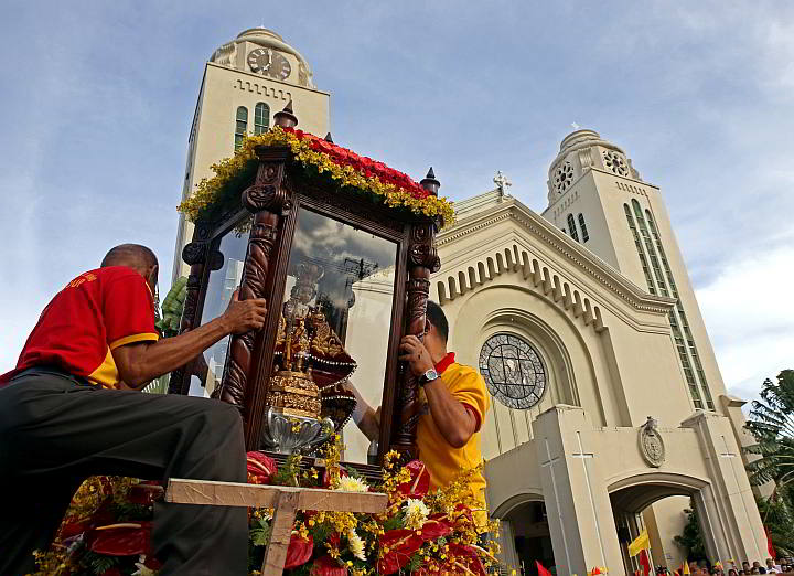 Volunteers carefully unload the glass-encased pilgrim image of the  Sto Niño upon arrival at the Redemptorist church  after a 6 a.m. motorcade  from the basilica. (CDN PHOTO/LITO TECSON) 