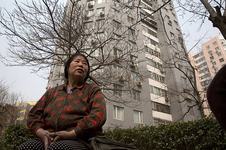 Chen Shuhong is interviewed in front of the residential compound where she rents out apartments as housing for cancer patients in Beijing. (AP Photo)