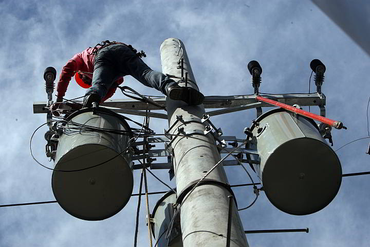 A contractor repairs a Veco line affected by the rotational brownouts in this 2014 photo. (CDN PHOTO/ TONEE DESPOJO)