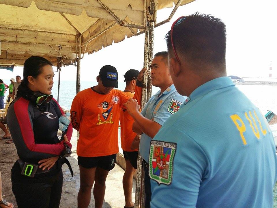FACEOFF. PO3 Elbert Dolino of Toledo City Police Station (left) tells lawyer Mary Joan Dulhao of Sea Knights to stop their diving activity for a marine assessment in barangay Poblacion.  Someone from Toledo City Hall gave the order, he said. (CDN photo Michelle Joy L. Padayhag)